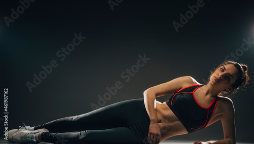 Attractive fitness woman on dark grey background