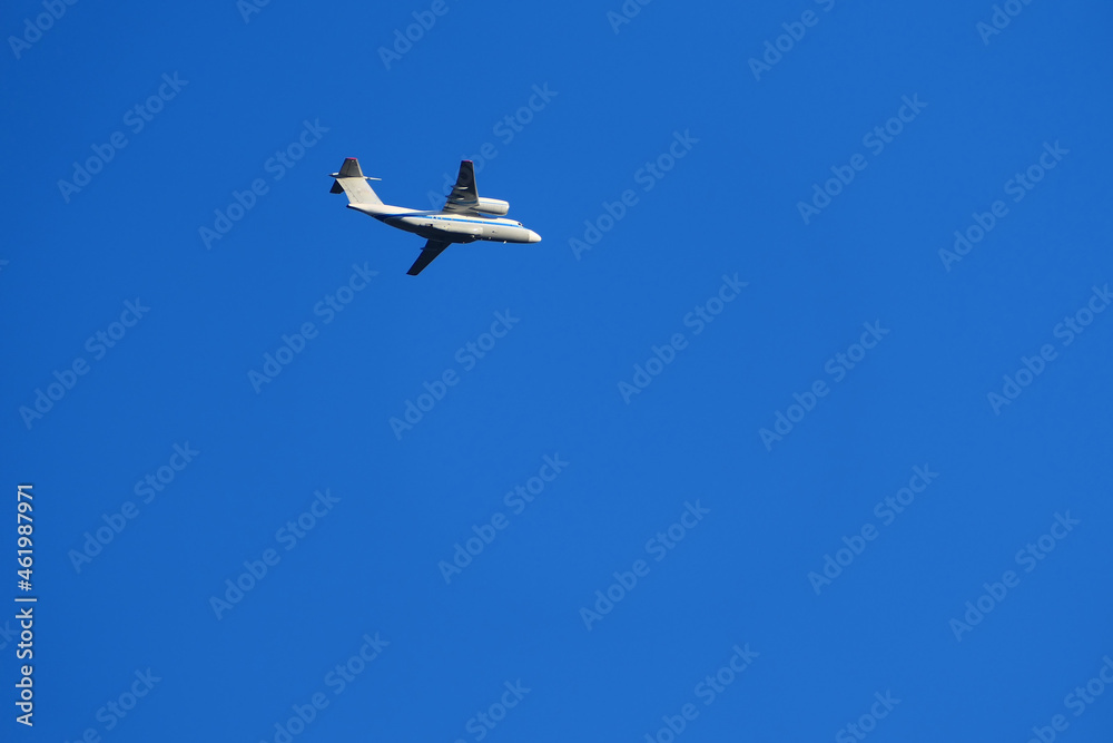 A passenger plane is flying in the sky. White passenger plane on a blue background. A passenger plane is flying in the sky. White passenger plane on a blue background.