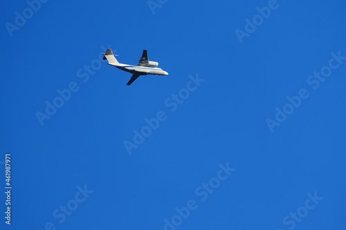 A passenger plane is flying in the sky. White passenger plane on a blue background.