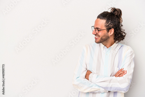 Young caucasian man isolated on gray background smiling confident with crossed arms. © Asier