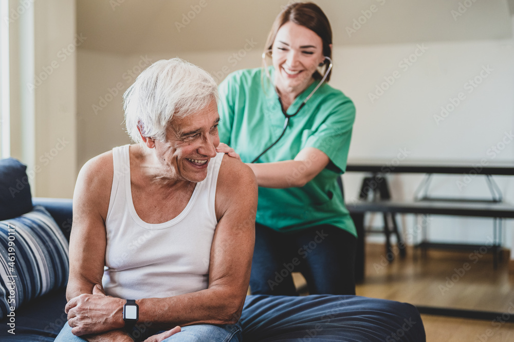 Obraz premium happy female nurse with a stethoscope visiting an elderly man, domestic medical assistant concept, smiling health visitor and a senior male patient, heartache prevention, copy space