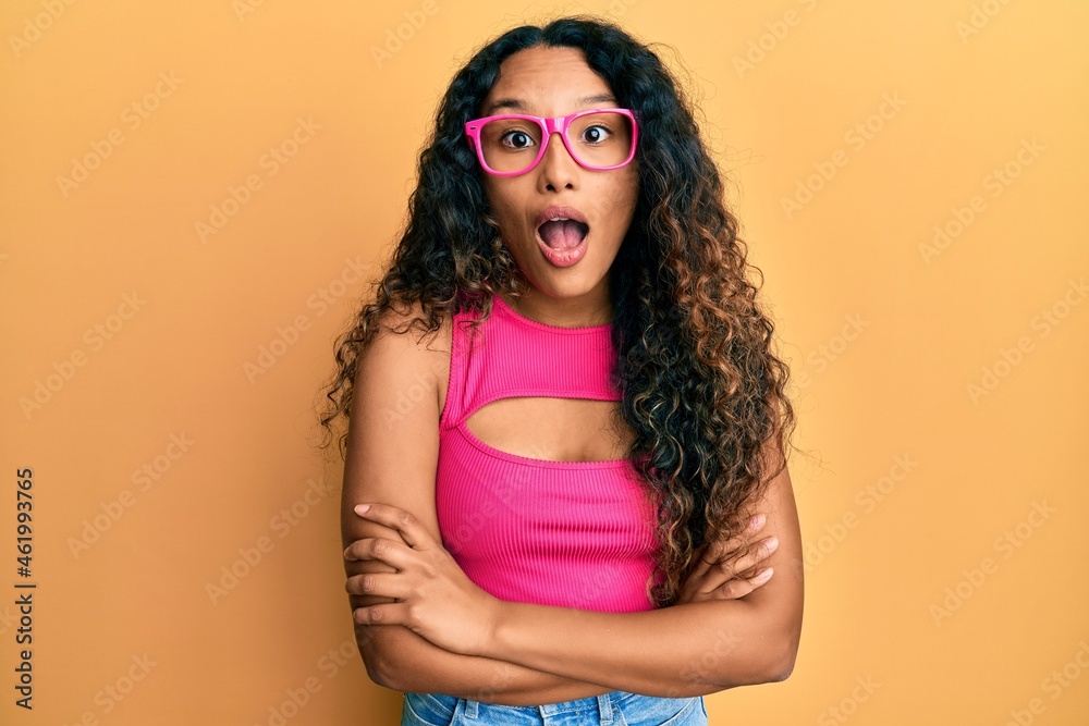 Young latin woman wearing casual clothes and glasses celebrating crazy and amazed for success with open eyes screaming excited. Young latin woman wearing casual clothes and glasses celebrating crazy and amazed for success with open eyes screaming excited.