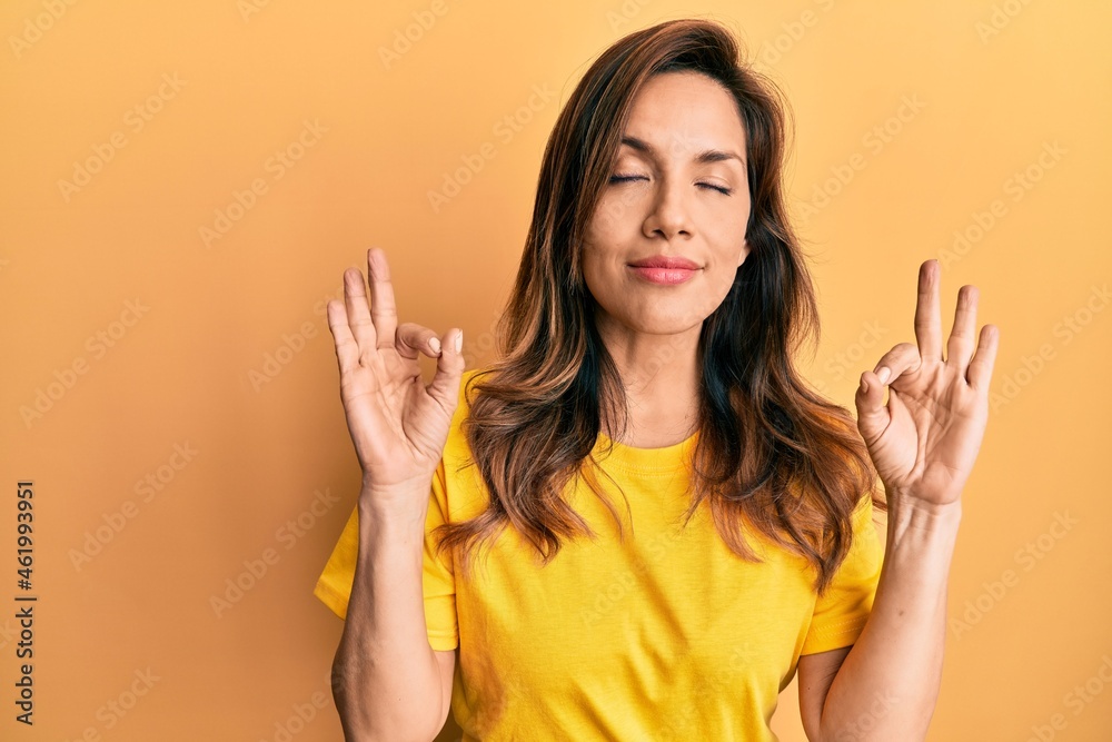 Young latin woman wearing casual clothes relax and smiling with eyes closed doing meditation gesture with fingers. yoga concept.
