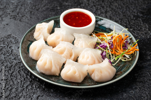 Traditional Asian Prawn or shrimp dumplings hakau, ha kauw or har gow. Served with cabbage, carrot salad and soy and sweet chilli sauce photo