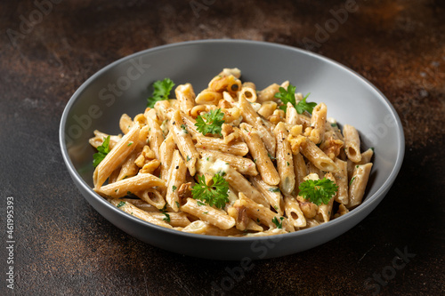 Whole Wheat Penne pasta with gorgonzola cheese sauce, spinach and walnut. Healthy food.