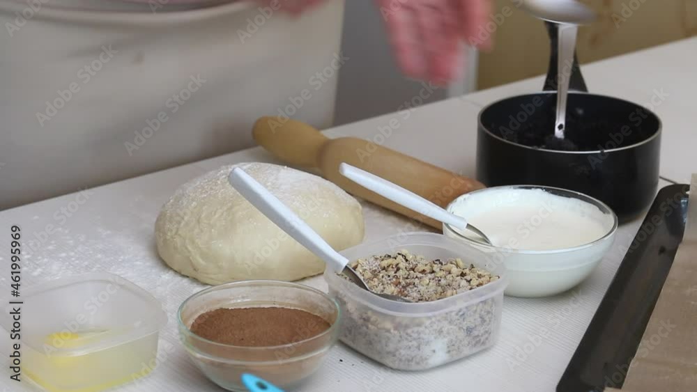 A woman prepares various fillings for buns.  There is a lump of dough next to it.  Making buns at home.  Close-up shot