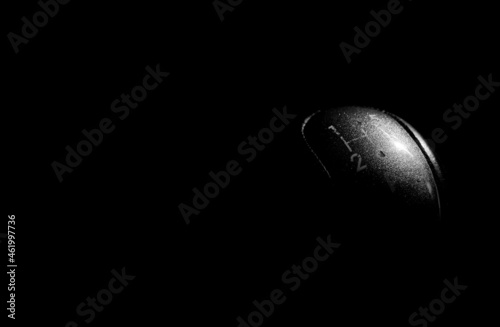 Monochrome image, used, worned gear shift knob on natural light isolated on dark background. photo