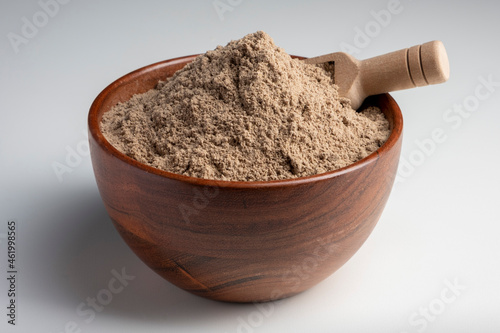 Raw flax seeds flour in a wooden bowl with on white background.