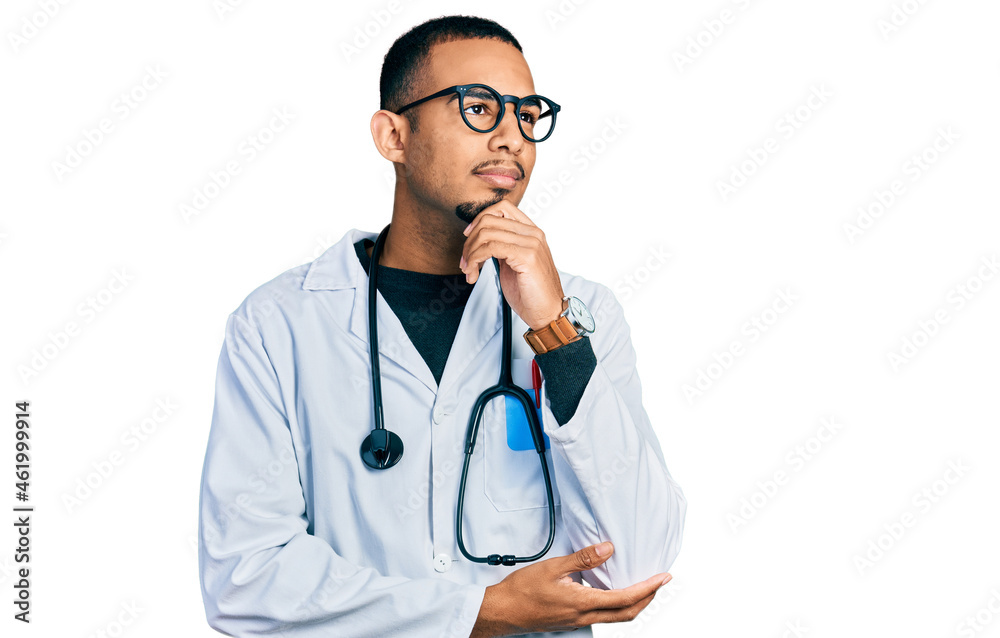 Young african american man wearing doctor uniform and stethoscope with hand on chin thinking about question, pensive expression. smiling and thoughtful face. doubt concept. Young african american man wearing doctor uniform and stethoscope with hand on chin thinking about question, pensive expression. smiling and thoughtful face. doubt concept.