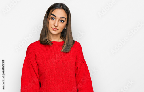 Beautiful brunette woman wearing casual winter sweater relaxed with serious expression on face. simple and natural looking at the camera.