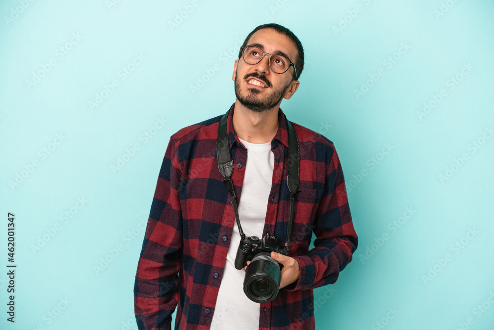 Young caucasian photographer man isolated on blue background dreaming of achieving goals and purposes Young caucasian photographer man isolated on blue background dreaming of achieving goals and purposes