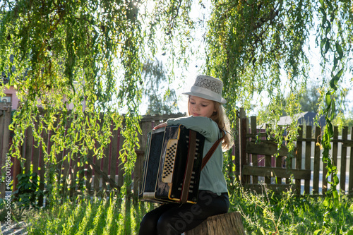 girl playing the accordion in the autumn park. autumn accordion. girl doing music. child in the autumn park