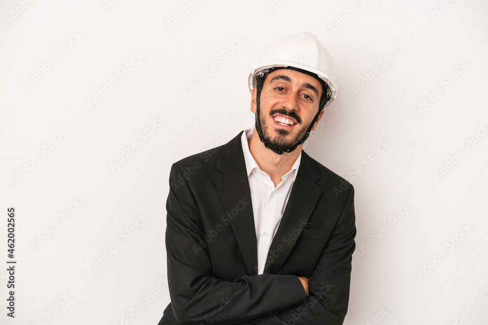 Young architect man wearing a construction helmet isolated on white background laughing and having fun. Young architect man wearing a construction helmet isolated on white background laughing and having fun.
