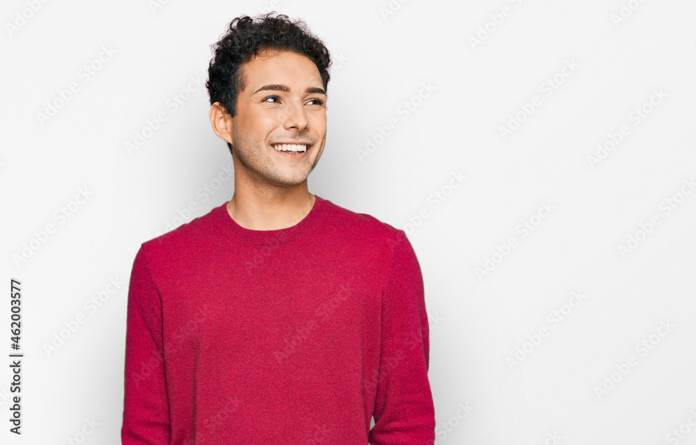 Young handsome man wearing casual clothes looking away to side with smile on face, natural expression. laughing confident.