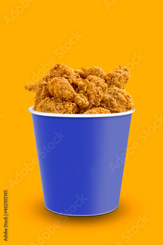 Tasty deep fried chicken pieces on orange background , closeup. chicken bucket. Space for text.