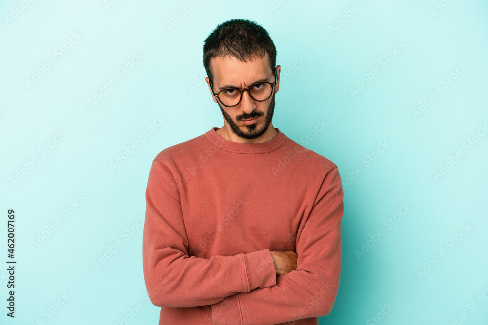 Young caucasian man isolated on blue background unhappy looking in camera with sarcastic expression. Young caucasian man isolated on blue background unhappy looking in camera with sarcastic expression.