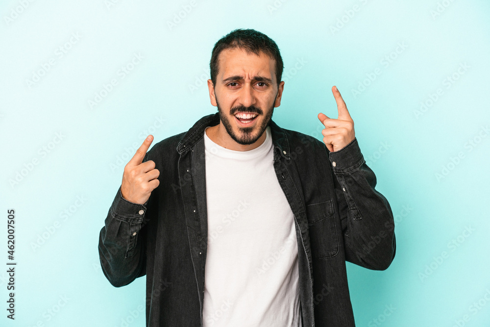 Fototapeta premium Young caucasian man isolated on blue background showing a disappointment gesture with forefinger.