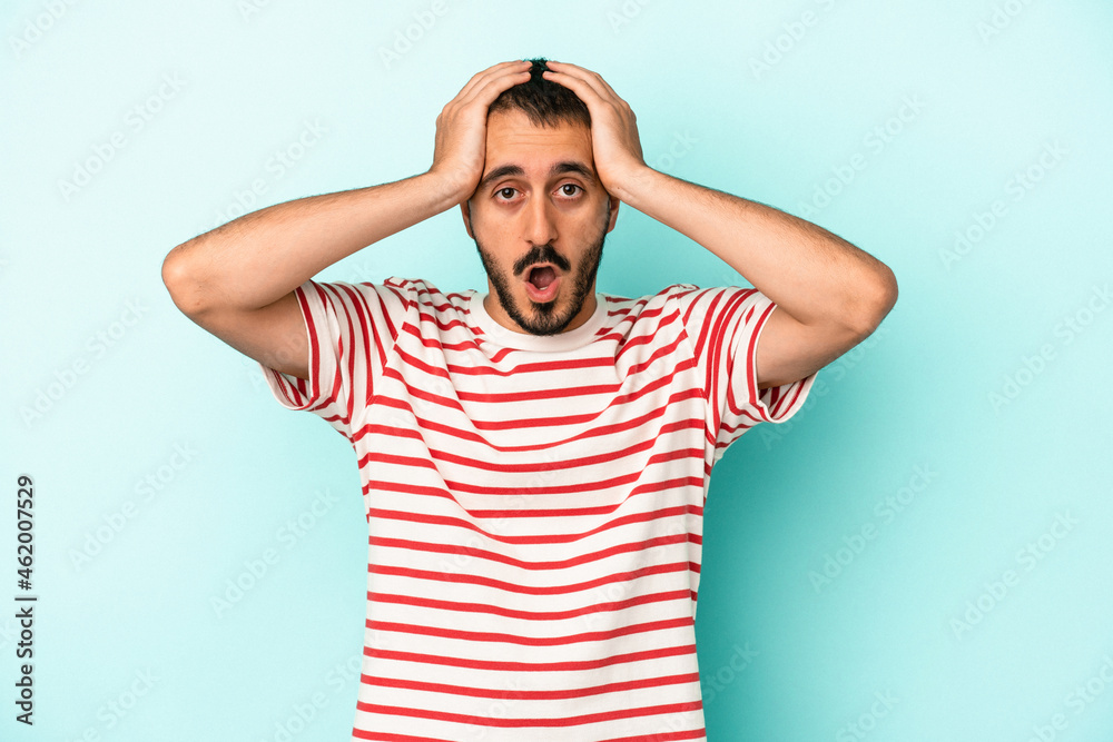 Fototapeta premium Young caucasian man isolated on blue background being shocked, she has remembered important meeting.
