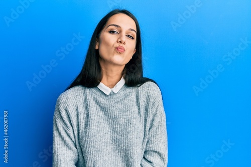 Young hispanic woman wearing casual clothes looking at the camera blowing a kiss on air being lovely and sexy. love expression.