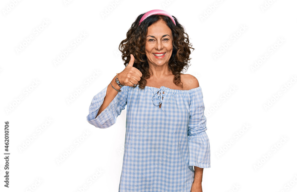 Middle age hispanic woman wearing casual clothes smiling happy and positive, thumb up doing excellent and approval sign Middle age hispanic woman wearing casual clothes smiling happy and positive, thumb up doing excellent and approval sign