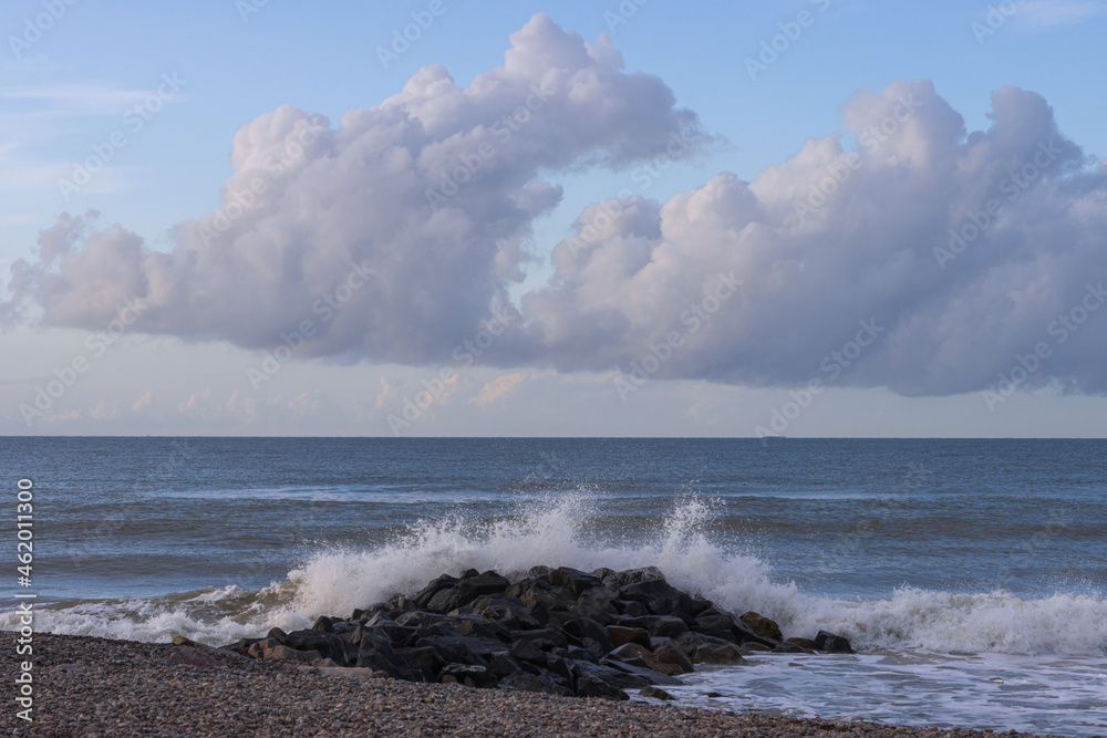 Welle kracht gegen Steinbuhne an der Nordsee.