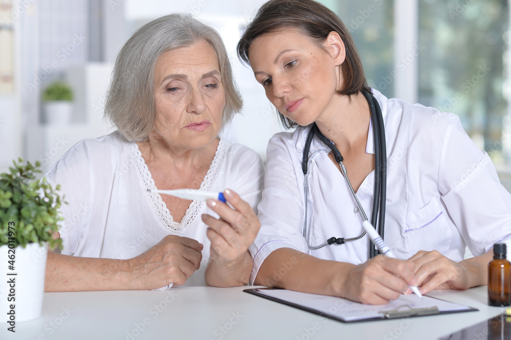 Doctor and patient looking on thermometer in hospital Doctor and patient looking on thermometer in hospital