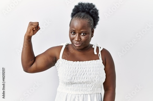 Young african woman standing over white isolated background strong person showin Fotobehang