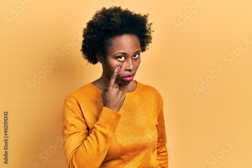 Young african american woman wearing casual clothes pointing to the eye watching you gesture, suspicious expression