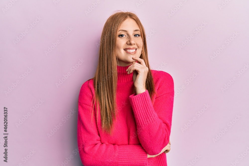 Young irish woman wearing casual clothes smiling looking confident at the camera with crossed arms and hand on chin. thinking positive. Young irish woman wearing casual clothes smiling looking confident at the camera with crossed arms and hand on chin. thinking positive.