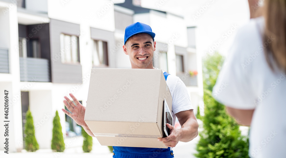 Young courier delivering goods to a young woman at home Young courier delivering goods to a young woman at home