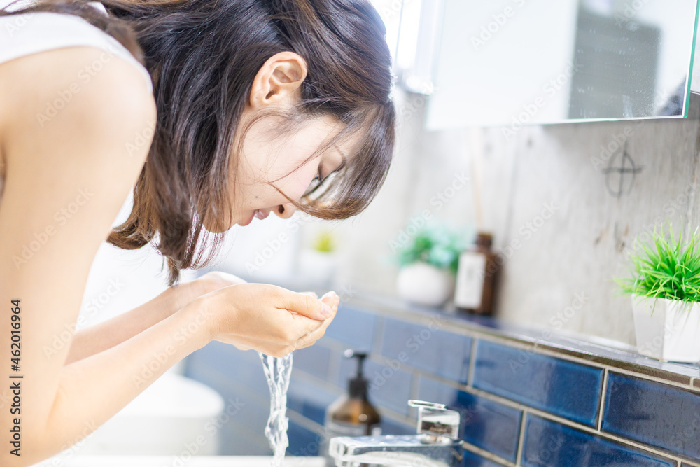 洗面所で洗顔をする若い女性 洗面所で洗顔をする若い女性