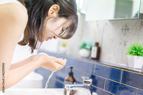 洗面所で洗顔をする若い女性
