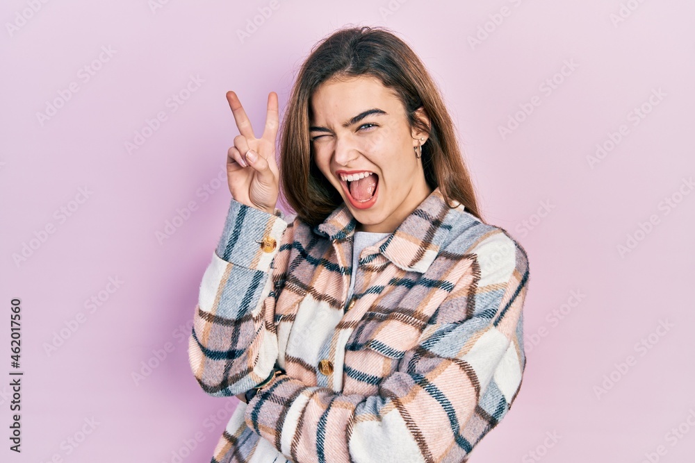 Young caucasian girl wearing casual clothes smiling with happy face winking at the camera doing victory sign with fingers. number two. Young caucasian girl wearing casual clothes smiling with happy face winking at the camera doing victory sign with fingers. number two.