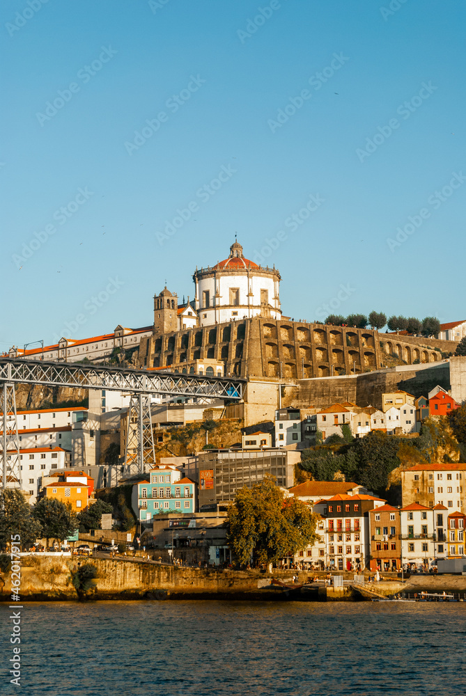Monastery of Serra do Pilar and Luis I Bridge at spectacular sunset as the sun lights up the scene colorful buildings and cristal blur sky - Portugal, Vertical