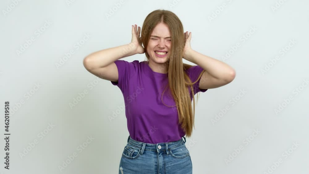 Teenager girl covering both ears with hands. Frustrated expression  over isolated background