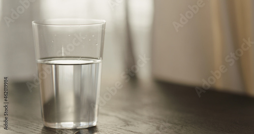 sparkling water in tumbler glass on black oak table with copy space