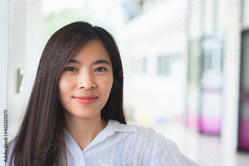 close up attractive adult business woman asian girl with happy and smile against white concrete wall office.