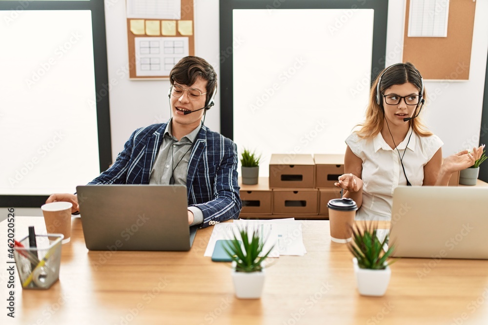 Two call center agent smiling happy having video call using laptop at the office. Two call center agent smiling happy having video call using laptop at the office.