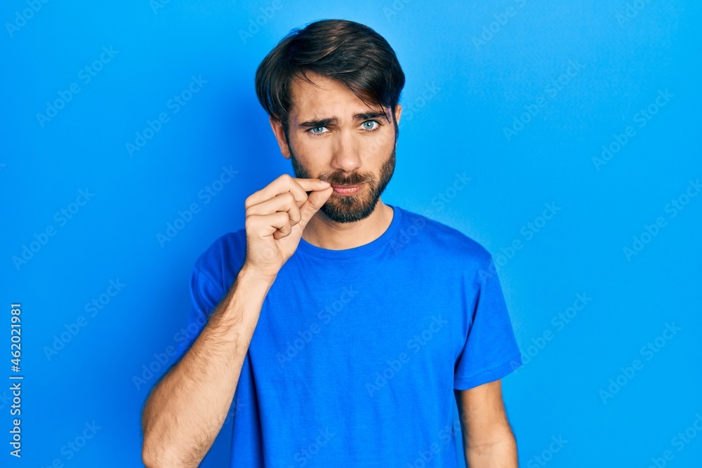Young hispanic man wearing casual clothes mouth and lips shut as zip with fingers. secret and silent, taboo talking Young hispanic man wearing casual clothes mouth and lips shut as zip with fingers. secret and silent, taboo talking