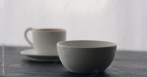 white bowl with espresso cup on black wood table