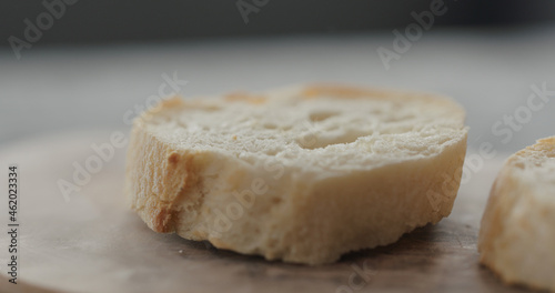 fresh baguette slice on olive board closeup