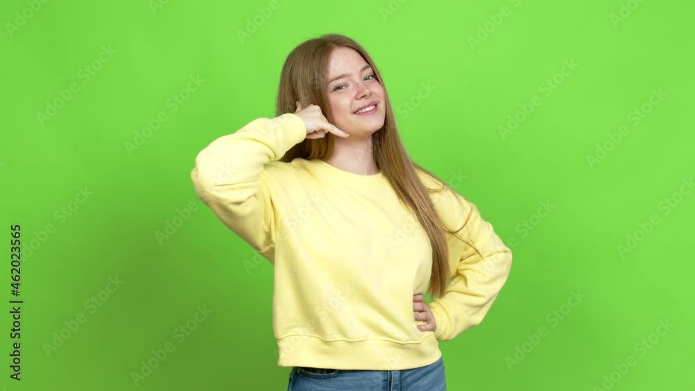 Teenager girl making phone gesture and speaking with someone. Call me back sign over isolated background. Green screen chroma key Teenager girl making phone gesture and speaking with someone. Call me back sign over isolated background. Green screen chroma key