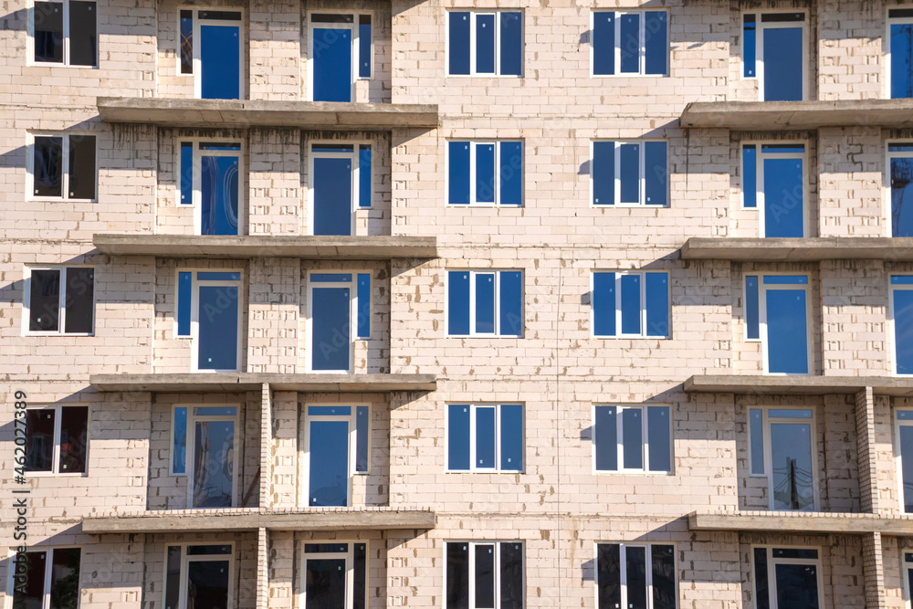 Obraz premium Brick walls of residential building under construction. Real estate, urban construction industry background photo