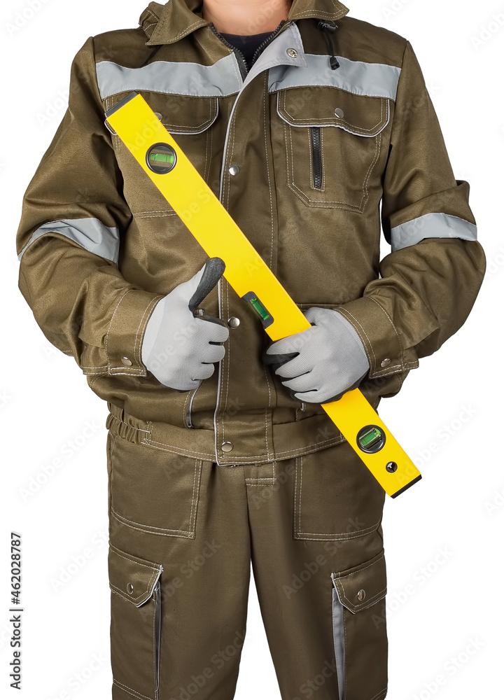A man, a builder or an engineer in a working uniform holds a work tool in his hands, isolated on a white background. A man, a builder or an engineer in a working uniform holds a work tool in his hands, isolated on a white background.