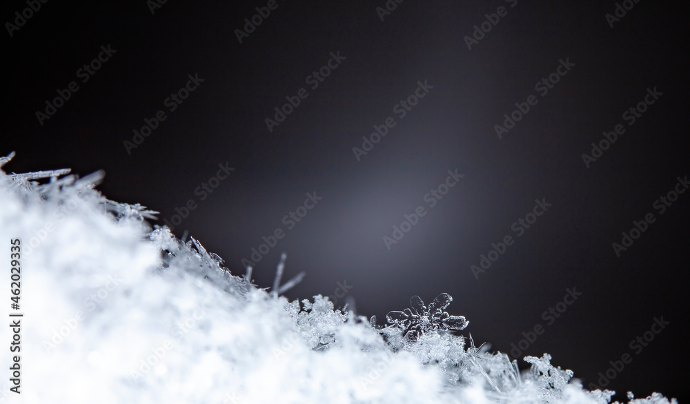 Snowflake. Macro photo of real snow crystal. Beautiful winter background seasonal nature and the weather in winter. 
