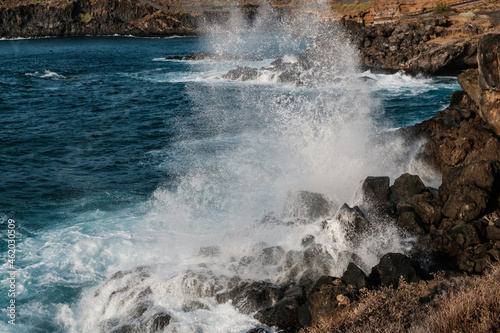 Waves crashing at rocks. Stormy weather at ocean coast .