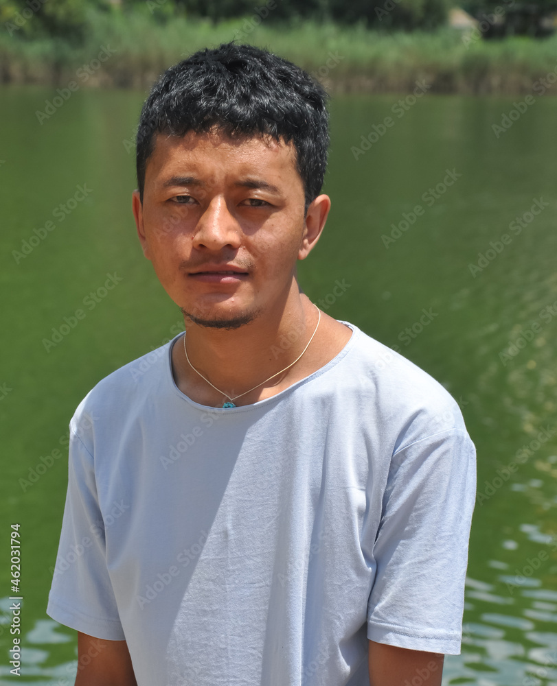 Portrait of a Ladakhi (North Indian) young guy looking at camera and standing beside of lake Portrait of a Ladakhi (North Indian) young guy looking at camera and standing beside of lake