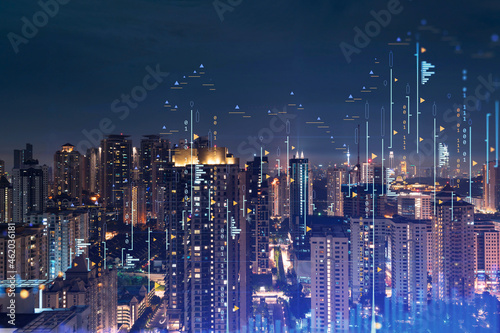 Stock market graph hologram, night panorama city view of Kuala Lumpur. KL is popular location to gain financial education in Malaysia, Asia. The concept of international research. Double exposure.