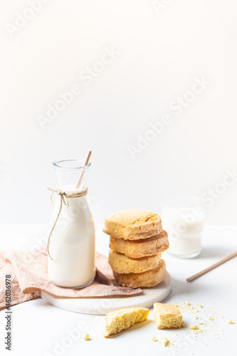 Freshly baked homemade honey cookies with milk for breakfast on a white background