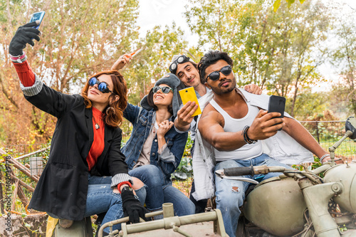 group of best friends take a selfie riding a vintage motorcycle with sidecar